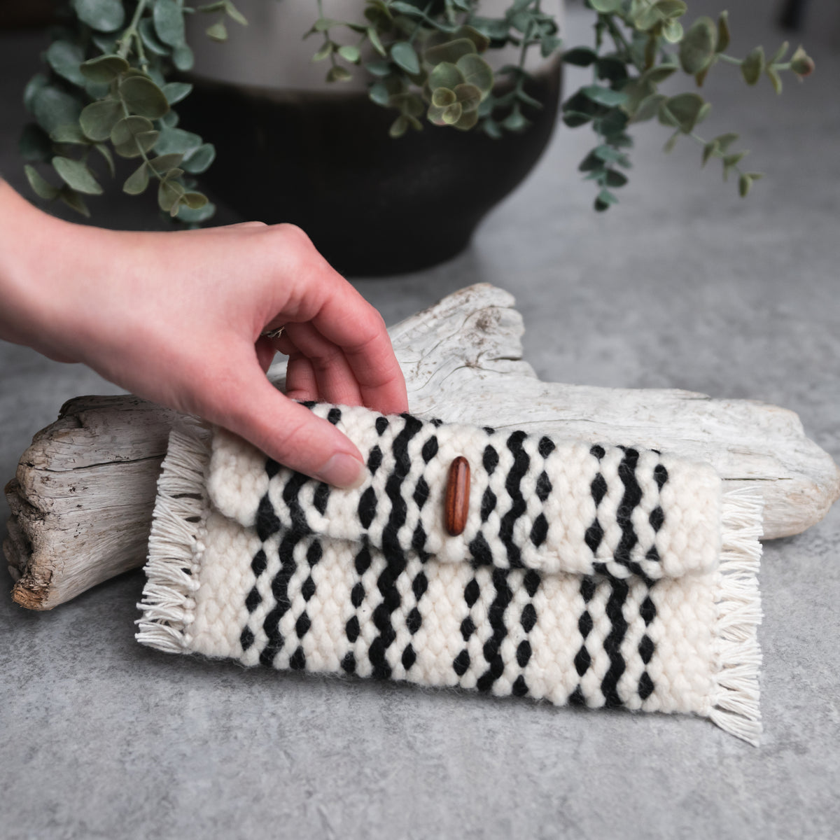 A picture of a black and white striped woven pouch.